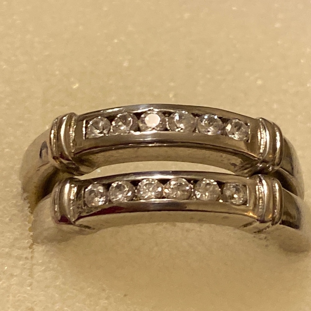 Sterling silver pair of band rings. White sapphire stones